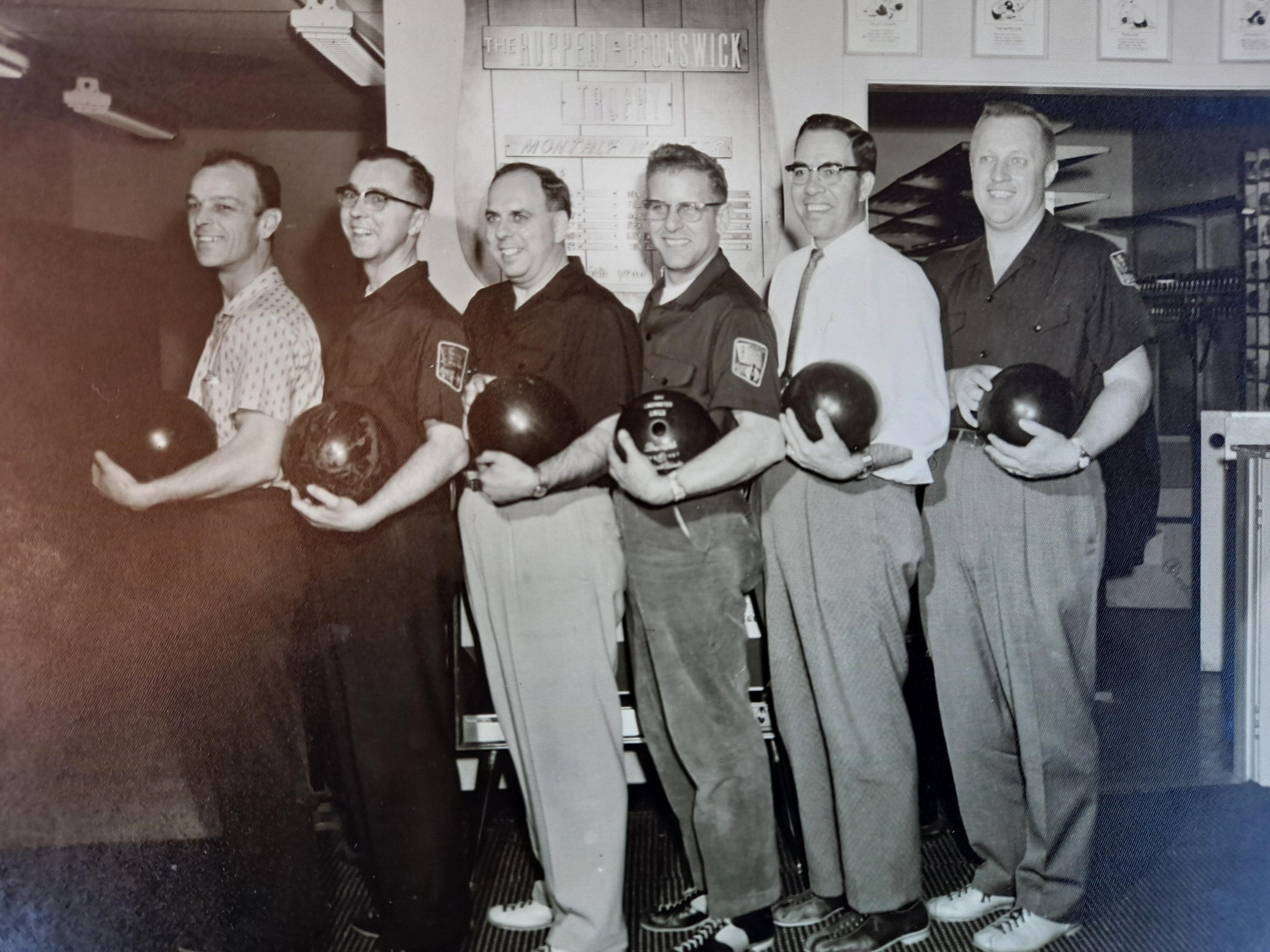 Six Lancaster Lions Club members posing with bowling balls at the Ruppert-Brunswick Trophy lanes