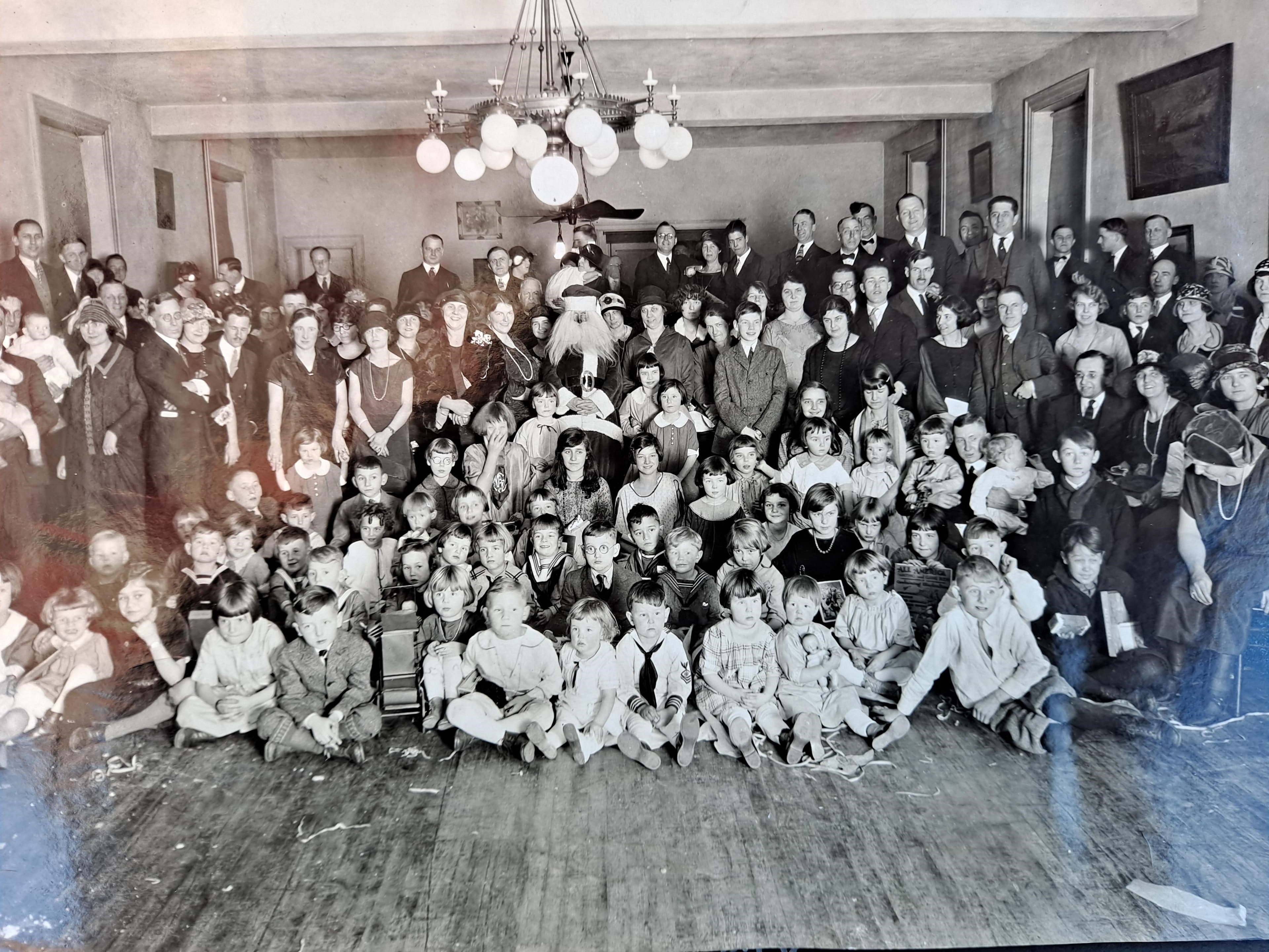Large indoor community gathering with adults and children, Lions Club community event circa 1923