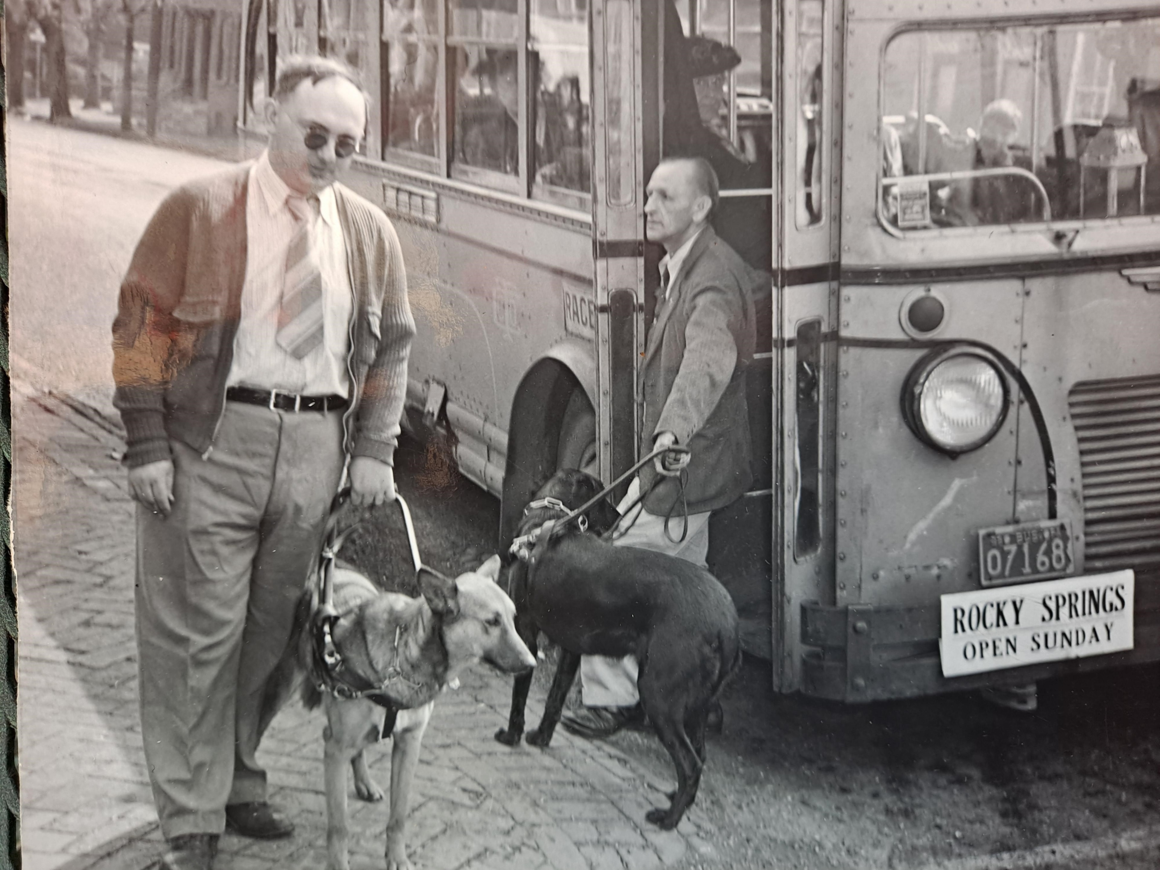 Two men with guide dogs boarding a Rocky Springs bus, Lancaster Pennsylvania
